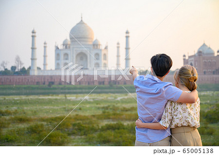 Explore India, Portrait of young couple looking at Taj Mahal 65005138