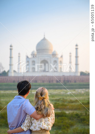 Explore India, Portrait of young couple looking at Taj Mahal 65005139