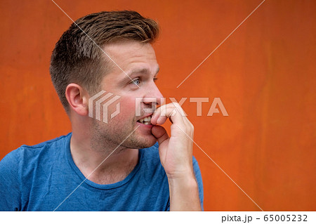 Caucasian mature man on red background gnawing 65005232