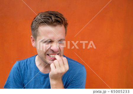 Caucasian mature man on red background gnawing 65005233