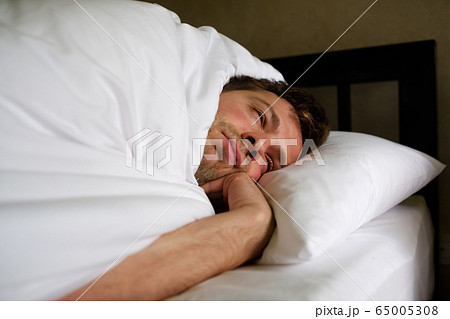 The tired caucasian man lay on the bed and cover 65005308