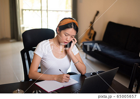 Busy woman on a phone meeting while working from 65005657
