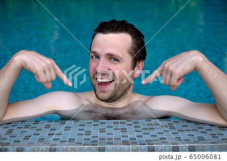 Proud caucasian young man looks forward showing Proud caucasian young man looks forward showing 65006081