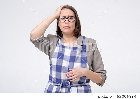 Sad upset tired businees woman in apron touch her 65006834
