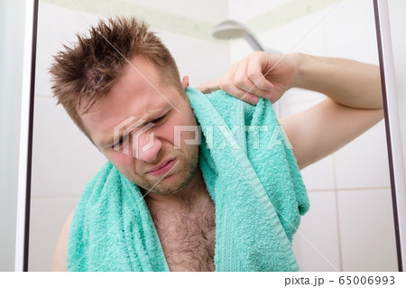 Young man cleaning his ear while taking a shower 65006993