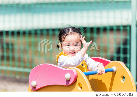 子供と家族 公園で遊ぶ可愛い女の子の写真素材