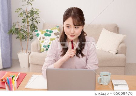 自宅のノートPCでオンラインセミナーを受ける若い女性 65009470