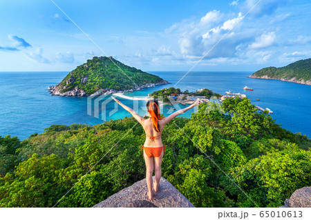 Woman in bikini standing at the viewpoint of Nang yuan island, Thailand. 65010613