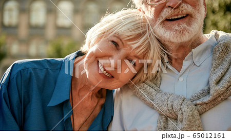 If it is real, it will never be over. Happy senior couple bonding to each other and smiling while sitting on the park bench together If it is real, it will never be over. Happy senior couple bonding to each other and smiling while sitting on the park bench together 65012161