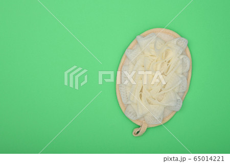Feminine bath shower puff over green background 65014221