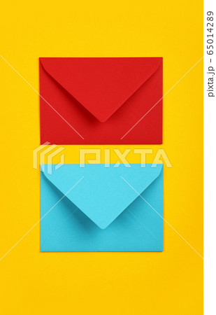 Two closed blue and red paper envelopes on yellow Two closed blue and red paper envelopes on yellow 65014289