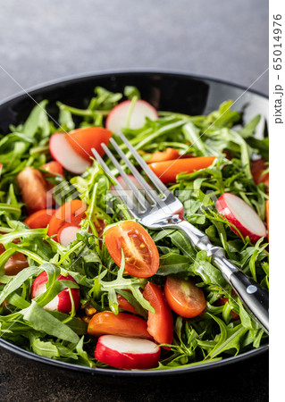 Fresh arugula salad with radishes, tomatoes and Fresh arugula salad with radishes, tomatoes and 65014976