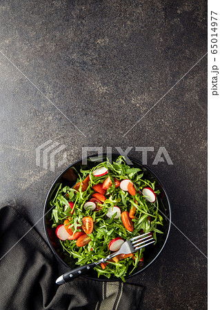 Fresh arugula salad with radishes, tomatoes and Fresh arugula salad with radishes, tomatoes and 65014977