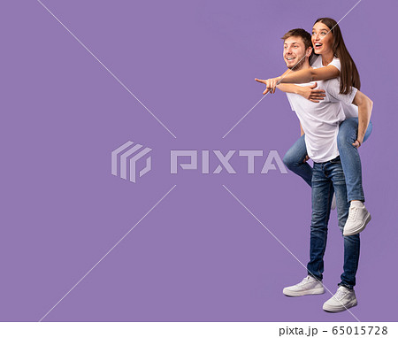 Happy couple pointing fingers up at free space Happy couple pointing fingers up at free space 65015728
