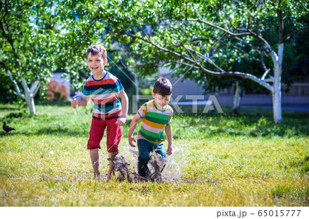 Little boy and his brother play in summer park. Little boy and his brother play in summer park. 65015777