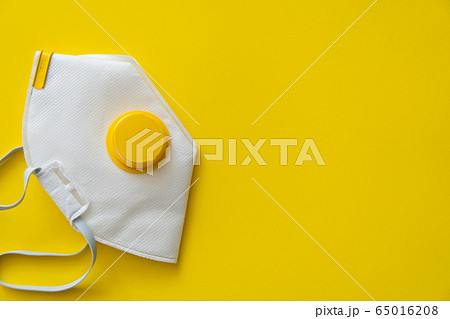 Respirator mask FFP or dust mask to cover the mouth and nose prevent coronavirus isolated on yellow background. Breathing protection against air pollution, flu and coronavirus. 65016208