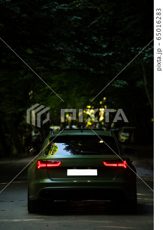 Grey offroader with red lights in a recreation zone across forest 65016283