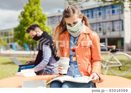Man and woman practicing social distancing in university 65016569