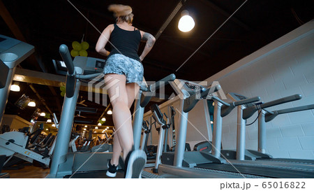 Girl runs on a treadmill in the gym 65016822