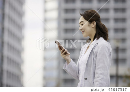 女性　ビジネス　屋外　スマホ　笑顔 65017517