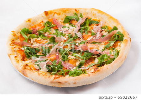 Pizza with arugula and jamon on a white background Pizza with arugula and jamon on a white background 65022667