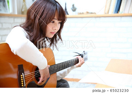 アコースティックギターを弾く女性イメージの写真素材