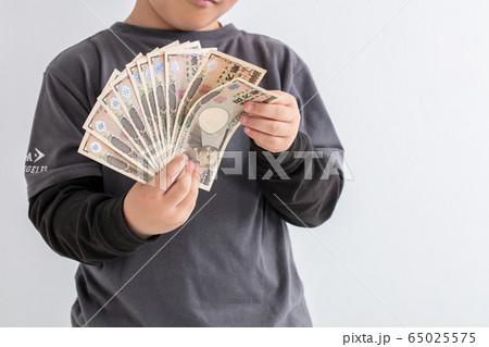 子供が10万円を持って数えている　子育て手当て　給付金 65025575