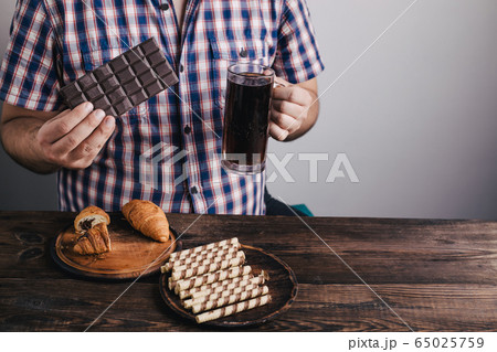 Overweight man with big amount of sugary food Overweight man with big amount of sugary food 65025759
