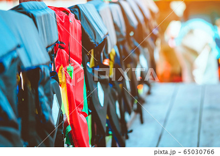 A green whistle with red life jacket hanging on the railing around the walkway for safely of passengers at the docks. A green whistle with red life jacket hanging on the railing around the walkway for safely of passengers at the docks. 65030766