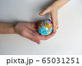 baby and hand of adult man holding a small globe during the epidemic 65031251