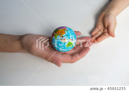 baby and hand of adult man holding a small globe during the epidemic baby and hand of adult man holding a small globe during the epidemic 65031255
