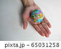 a man's adult hand holds a small globe in the palm 65031258