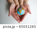 baby and hand of adult man holding a small globe during the epidemic 65031265