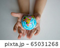 children's hands hold a small globe during a coronavirus 65031268
