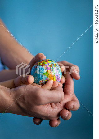 baby and hand of adult man holding a small globe during the epidemic baby and hand of adult man holding a small globe during the epidemic 65031271