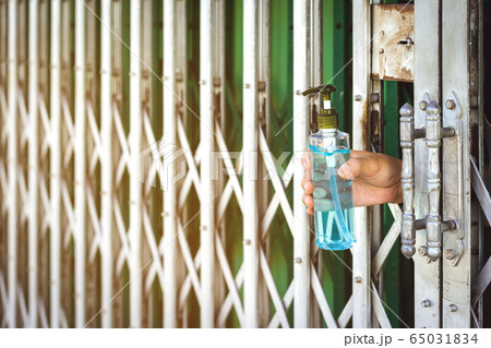 A woman wear surgical face mask and home quarantine herself in house by giving alcohol gel to clean germs to people who deliver food. Physical distancing for protect Covid-19 concept. A woman wear surgical face mask and home quarantine herself in house by giving alcohol gel to clean germs to people who deliver food. Physical distancing for protect Covid-19 concept. 65031834