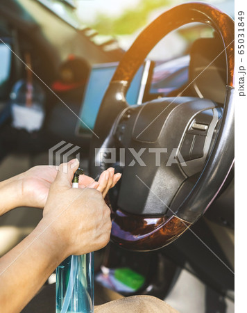 A woman wash her hands with blue alcohol gel to kill germs before driving car for hygiene purposes and prevents the spread of germs and avoids coronavirus (Covid-19) infection. Health care concept. 65031849