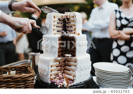 photo of a three layered white cake 65032783