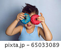 boy is holding two colored doughnuts blue and red in front 65033089