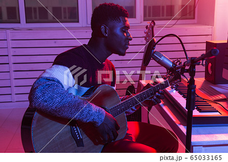African american professional musician recording guitar in digital studio at home, music production technology concept, close-up. African american professional musician recording guitar in digital studio at home, music production technology concept, close-up. 65033165