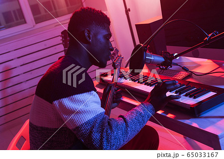 Create music and a recording studio concept - african american man guitarist recording synthesizer track in home studio Create music and a recording studio concept - african american man guitarist recording synthesizer track in home studio 65033167