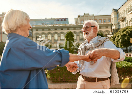 You are my soul! Beautiful senior couple smiling and dancing outdoors on a sunny day 65033793