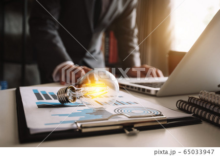light bulb with business hand working with tablet, laptop computer and creative business strategy in morning light 65033947