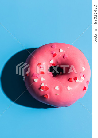 Trendy sunlight. Doughnut on bright light blue turquoise background. Minimal summer concept. Pop art style. Pink donut. Trendy sunlight. Doughnut on bright light blue turquoise background. Minimal summer concept. Pop art style. Pink donut. 65035453