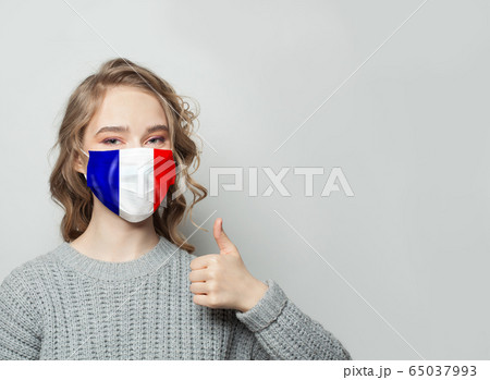 Happy woman in face mask holding thumb up Happy woman in face mask holding thumb up 65037993
