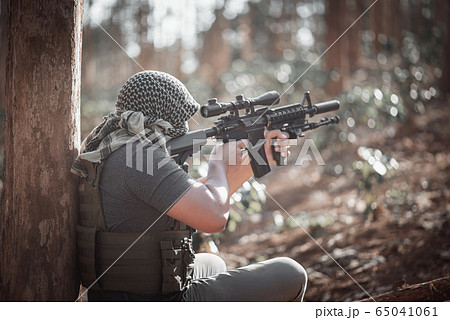 Man terrorist wearing a mask and holding a gun, 65041061