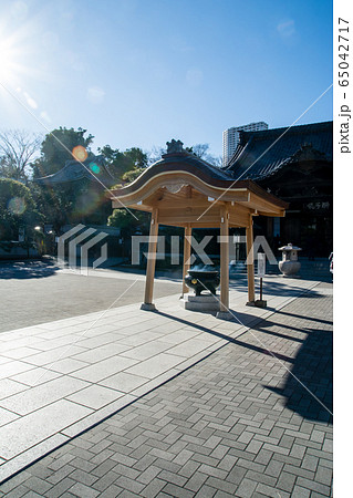 真っ青な快晴の空の下　泉岳寺の境内の常香炉に注ぐまぶしい太陽 65042717