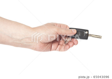 Hand with a car key isolated on white background Hand with a car key isolated on white background 65043096