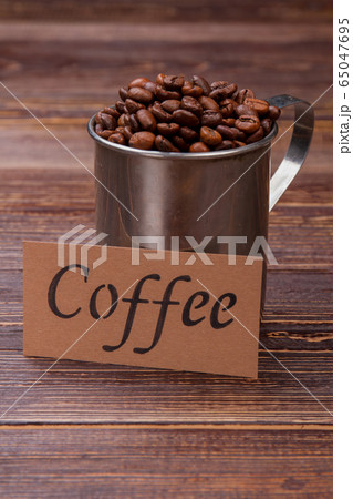 Many coffee beans in a steel mug. Many coffee beans in a steel mug. 65047695