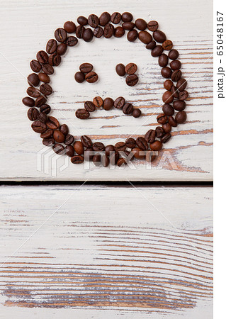Unhappy smiley face made of coffee beans. Unhappy smiley face made of coffee beans. 65048167